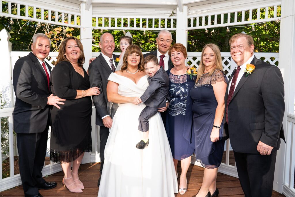 photo of bride and groom and wedding party in outside gazebo