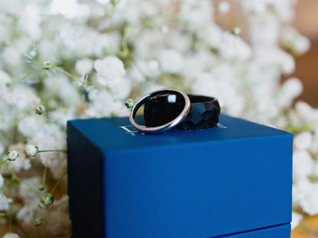 up close photo of wedding rings sitting on a blue box